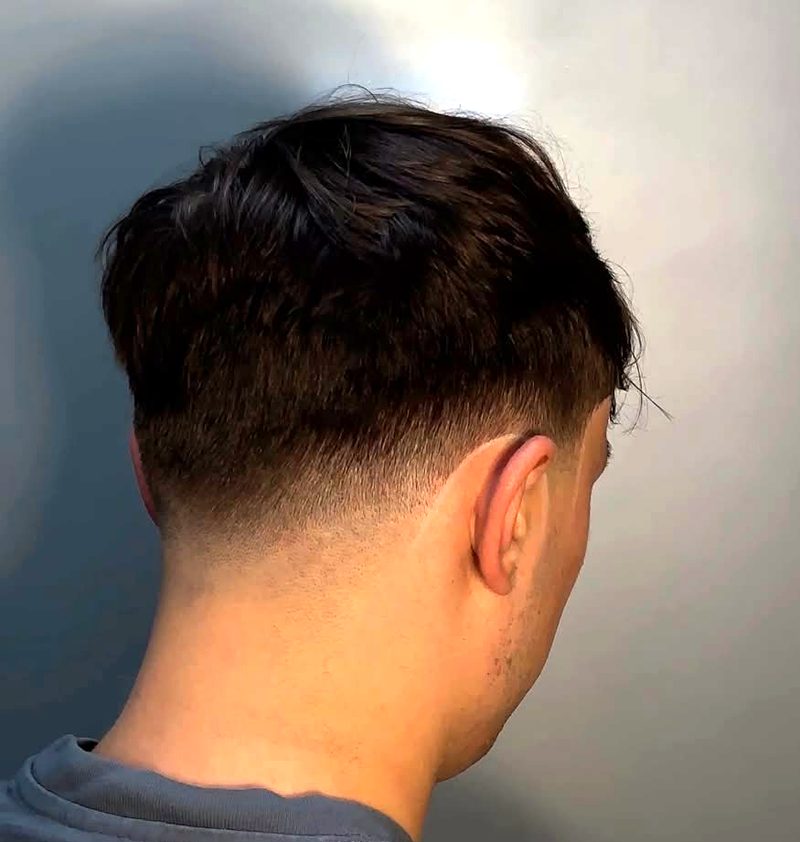 Fade im Nacken unter längerem Deckhaar, Ansicht von hinten